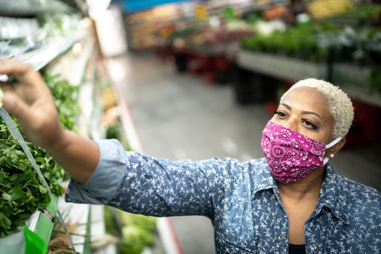 Woman with face mask shopping at supermarket.