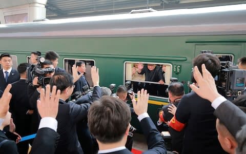 Kim Jong-un waving from his train as it prepares to depart from Beijing railway station earlier this week - Credit: AFP