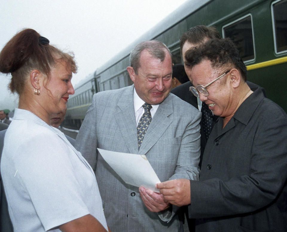 FILE - North Korea's leader Kim Jong Il, right, and Konstantin Pulikovsky, the Russian President's representative in the Far East, center, look at a photo of Larisa Denezhko, left, greeting his father and predecessor, Kim Il Sung, during a visit to the Soviet Union 13 years ago, after he crossed the Russian-North Korean border, south of Vladivostok, on July 26, 2001. North Korea’s Kim Jong Un's train journey to Russia has a storified history. The tradition of train travel extends across the generations. That’s in evidence at the massive Kumsusan Palace of the Sun, where reconstructions of Kim Jong Un’s father’s and grandfather’s train cars, and the leaders’ preserved and displayed remains, are enshrined. (AP Photo/Igor Kochetkov, File)