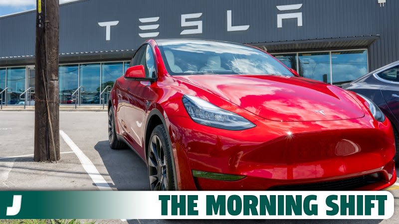 A red Tesla Model 3 seen on a lot outside a Tesla store.