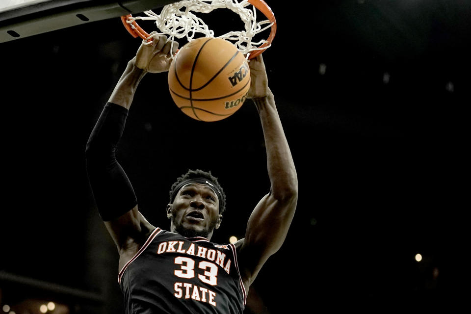 Oklahoma State forward Moussa Cisse (33) dunks the ball during the first half of an NCAA college basketball game against Texas in the second round of the Big 12 Conference tournament Thursday, March 9, 2023, in Kansas City, Mo. (AP Photo/Charlie Riedel)