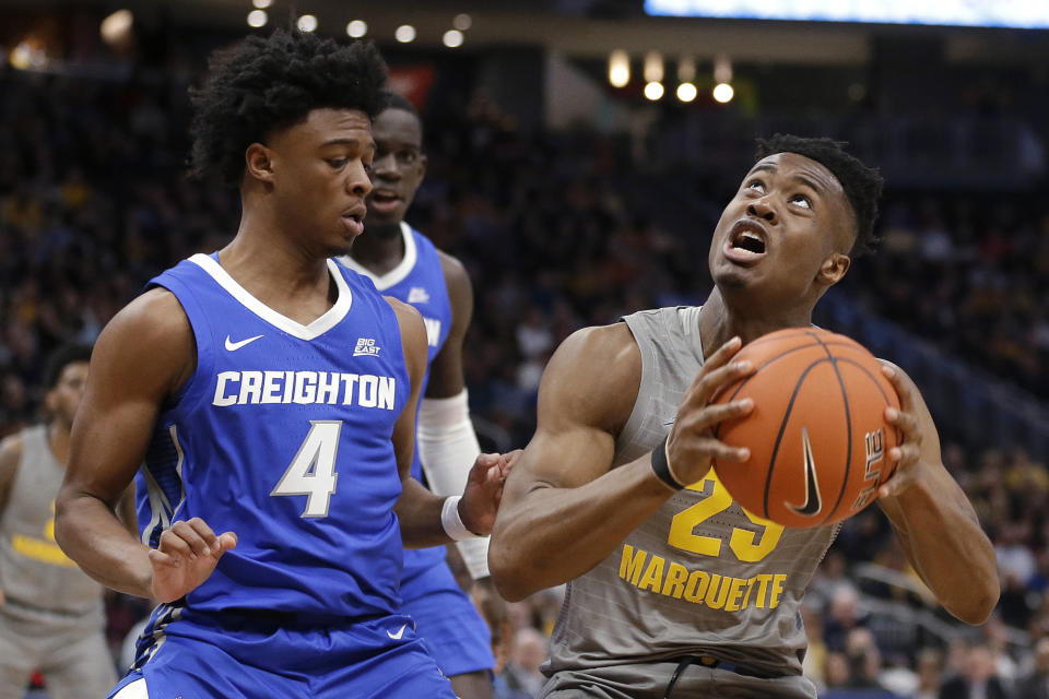 Marquette's Koby McEwen (25) looks for a shot next to Creighton's Shereef Mitchell (4) during the first half of an NCAA college basketball game Tuesday, Feb. 18, 2020, in Milwaukee. (AP Photo/Aaron Gash)