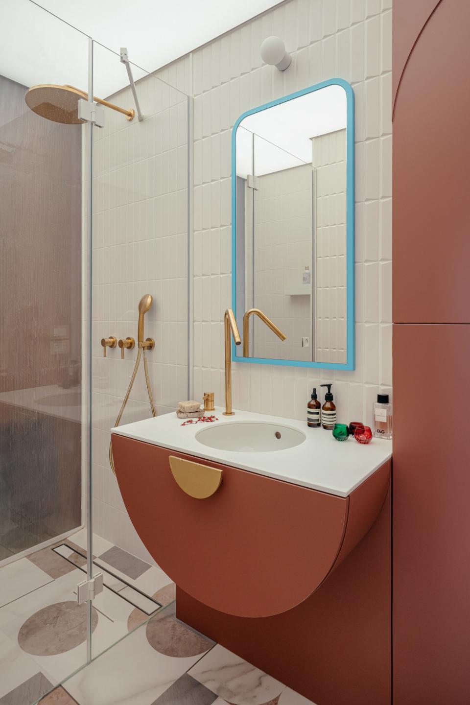 The bathroom wasn’t always this bright. Magdalena multiplied the light by swapping one wall for a glass partition and adding a luminous Barrisol ceiling membrane. The wall tiles, sourced from Italian ceramic brand 41zero42, mimic the lines of the fireplace in the living room. As for the floor, the designer animated it with colorful geometric marble patterns. The faucets are by Bellosta Rubinetterie.