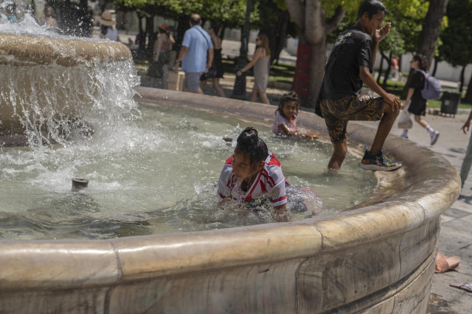 Children cool themselves in a fountain of the central Syntagma square during a hot day in Athens, Friday, July 14, 2023. Temperatures were starting to creep up in Greece, where a heatwave was forecast to reach up to 44 degrees Celsius in some parts of the country over the weekend. (AP Photo/Petros Giannakouris)