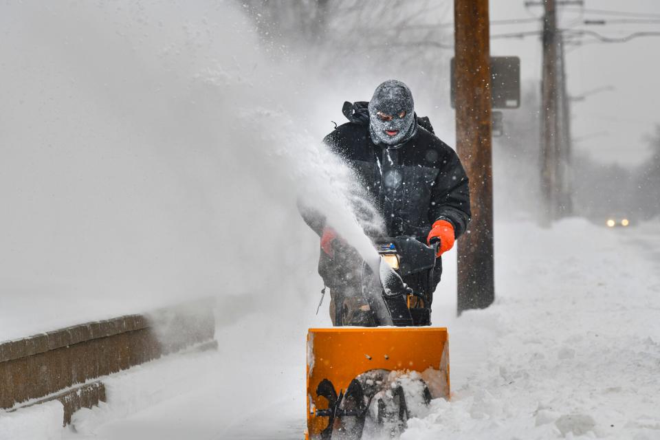 Scott Sprecher works to remove snow from a sidewalk Monday, Dec. 27, 2021, in St. Cloud. 