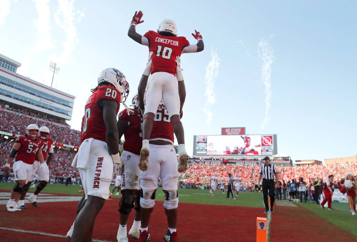 N.C. State offensive lineman Jacarrius Peak (65) lifts up wide receiver KC Concepcion (10) after Concepcion scored on a 72-yard touchdown reception during the second half of N.C. State’s 24-17 victory over Clemson at Carter-Finley Stadium in Raleigh, N.C., Saturday, Oct. 28, 2023. Ethan Hyman/ehyman@newsobserver.com