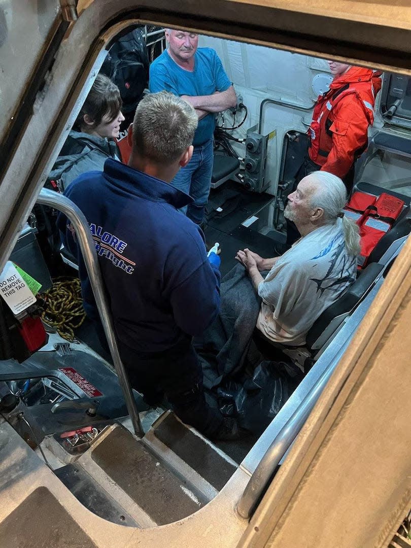 U.S. Coast Guard crews from Station Chetco River rescue two people from their boat after it capsized June 6 off the coast of Nesika Beach.