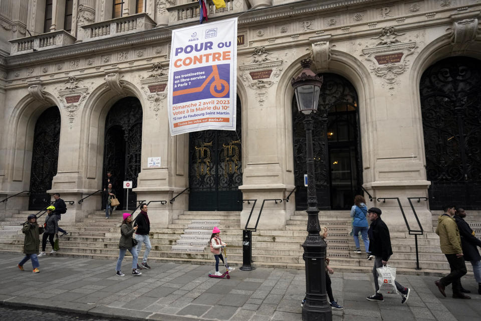 A banner reads "For or against self service scooters in Paris" on the facade of the city hall of the 10th district of Paris, Sunday, April 2, 2023. The wheels may be about to come off Paris' experiment with for-hire electric scooters. That's if Parisians vote on Sunday to do away with the 15,000 opinion-dividing micro-vehicles. (AP Photo/Thibault Camus)