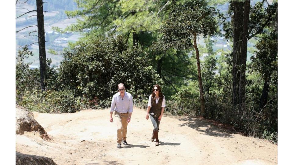 Prince William and Princess Visit India and Bhutan walking up a mountain in outdoors clothes