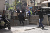 Supporters of a Shiite group allied with Hezbollah fire weapons during armed clashes that erupted during a protest in the southern Beirut suburb of Dahiyeh, Lebanon, Thursday, Oct. 14, 2021. It was not immediately clear what triggered the gunfire, but tensions were high along a former civil war front-line between Muslim Shiite and Christian areas. (AP Photo/Hassan Ammar)