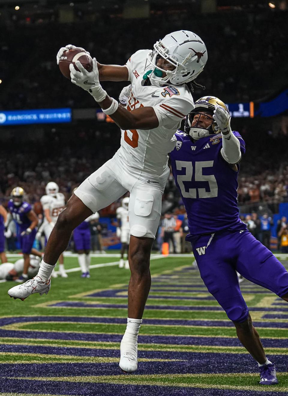 Texas Longhorns wide receiver Adonai Mitchell (5) makes a touchdown catch over Washington cornerback Elijah Jackson during the Sugar Bowl College Football Playoff semifinals game at the Caesars Superdome on Monday, Jan. 1, 2024 in New Orleans, Louisiana. The catch would be the last touchdown for the Longhorns in the 31-37 loss to Washington.