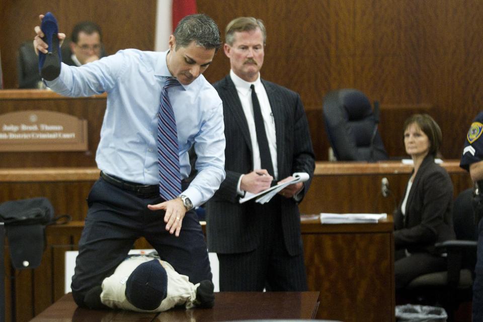 Prosecutor John Jordan does a crime scene demonstration, using a dummy, during the trial against Ana Trujillo Tuesday, April 1, 2014, in Houston. Trujillo, 45, is charged with murder, accused of killing her 59-year-old boyfriend, Alf Stefan Andersson with the heel of a stiletto shoe, at his condominium in June 2013. Defense attorney Jack Carroll, center, and crime scene investigator Christopher Duncan are shown in the background. (AP Photo/Houston Chronicle, Brett Coomer ) MANDATORY CREDIT.