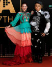 Taiwanese singer and television host Dee Hsu in a multicoloured frilled dress(L) poses with television host Kevin Tsai on the red carpet at the 27th Golden Melody Awards in Taipei, Taiwan June 25, 2016. (Reuters/Tyrone Siu)