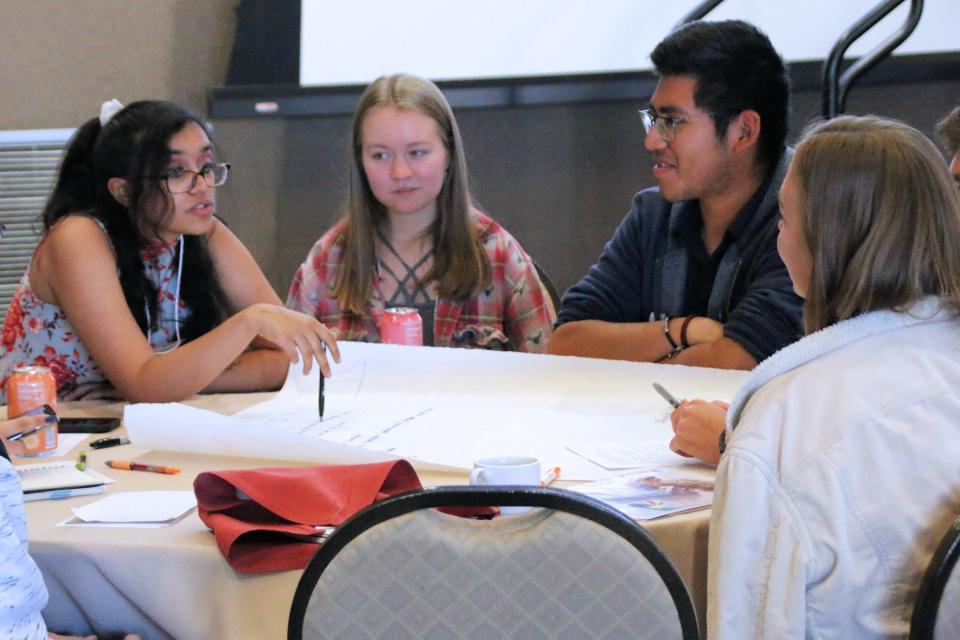 Aditi Narayana, left, discusses ideas for economic solutions to address climate change with Ryan Harrop, center, and Brian Mecinas, right, during the youth forum at the conference “Climate 2020: Seven Generations for Arizona” at Northern Arizona University in Flagstaff on Saturday.