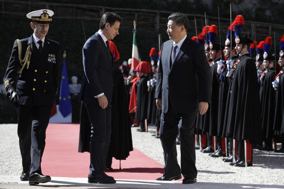 Chinese President Xi Jinping, right, and Italian Premier Giuseppe Conte walk past the honor guard during their meeting at Rome's Villa Madama, Saturday, March 23, 2019. (AP Photo/Andrew Medichini)