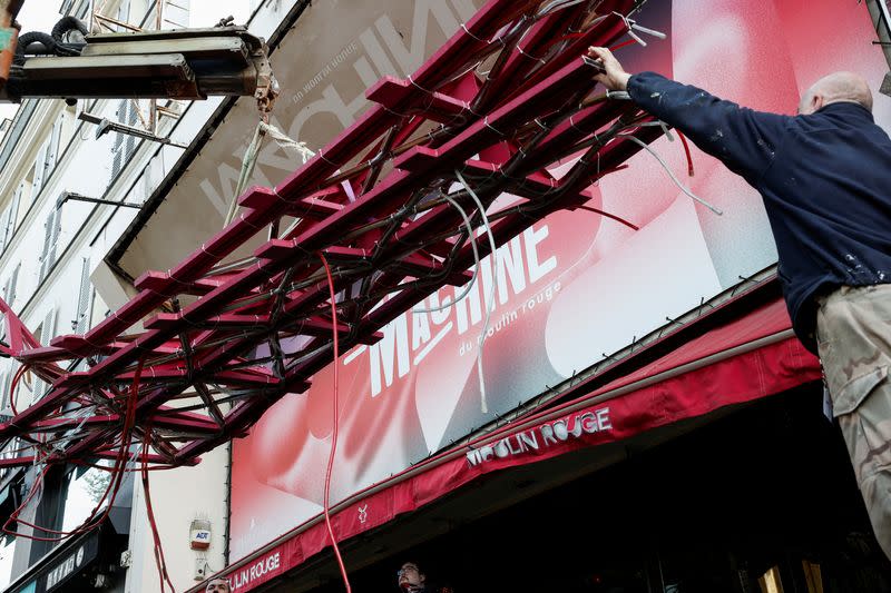 The broken sails of the landmark red windmill atop the Moulin Rouge, Paris' most famous cabaret club, are taken away after they fell off during the night in Paris