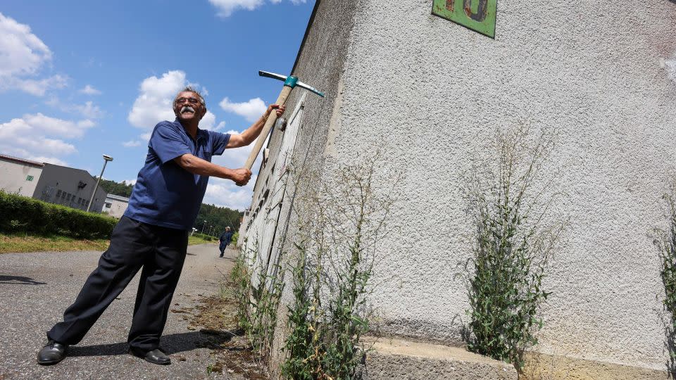 Čeněk Růžička poses with a pick during the official start of the demolition of the industrial pig farm on the site of the Lety camp. Those present recall his euphoria on that day. - Tomas Novak/AFP/Getty Images