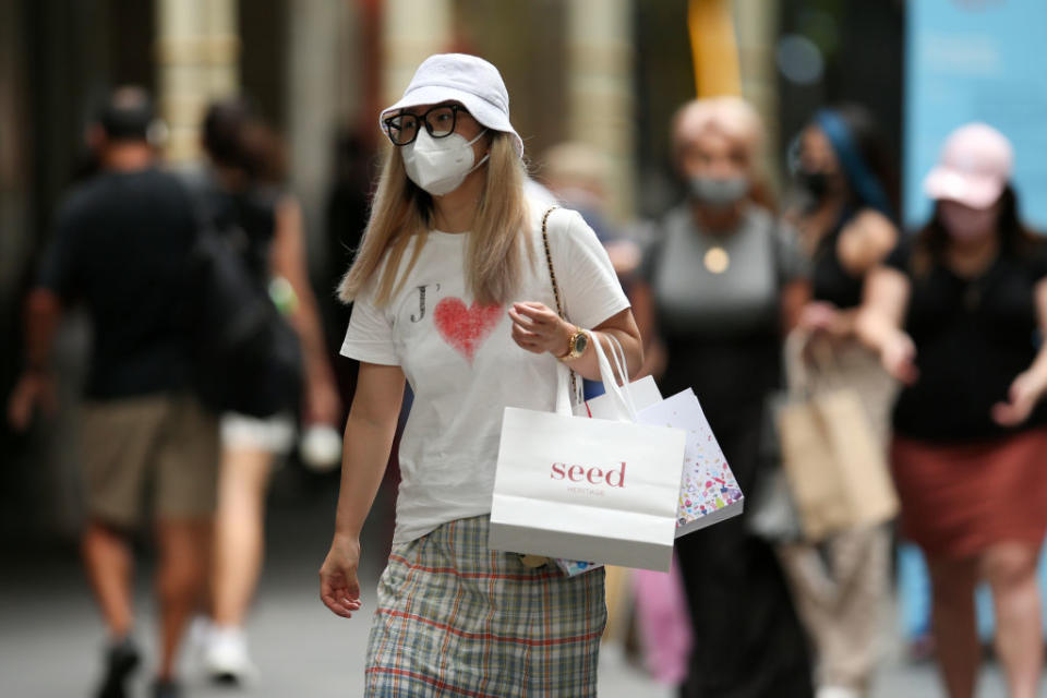 A shopper walks in Sydney's CBD Sydney, Australia wearing a face mask.