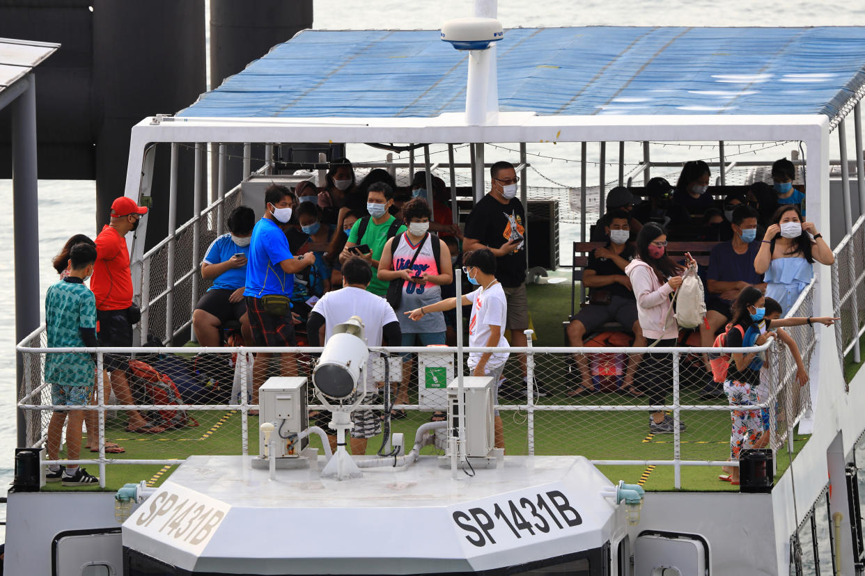 Passengers on board a ferry departing to a nearby offshore island at the Marina Bay Cruise Centre in Singapore.