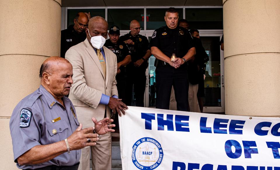 The Rev. Israel Suarez, a chaplain for the Fort Myers Police Department says a prayer during a candlelight vigil to honor law enforcement at the Federal Courthouse in downtown Fort Myers on Wednesday, Jan. 26, 2022. The local chapter of the NAACP held the vigil to promote unity among law enforcement and the community. They held the event in light of the recent police shootings in New York. Behind Suarez is James Muwakkil, president of the local chapter of the NAACP along with members of the Fort Myers Police Department including Deputy Chief Jeffrey Meyers (holding candle) and other law enforcement agencies. 