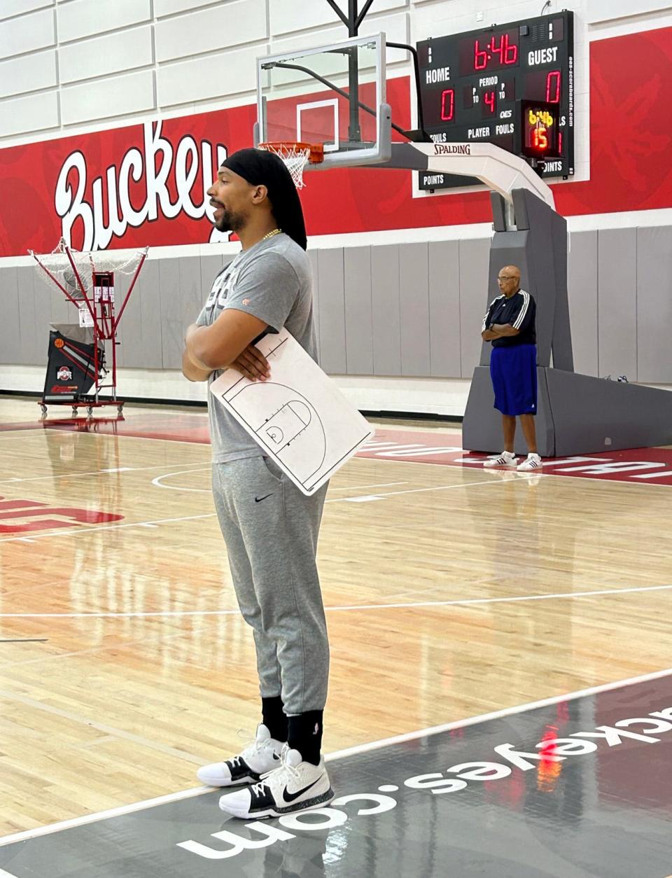 Carmen's Crew coach Jared Sullinger watches his team practice as his father and assistant coach, Satch, looks on from the baseline.