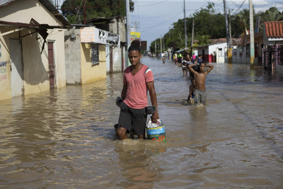 Habitantes caminan por una calle inundada tras el paso del huracán María en Arenoso (República Dominicana). El desbordamiento de ríos sigue causando daños en República Dominicana, cuatro días después de que el ciclón María se acercara a la costa este y noreste del país, donde miles de personas siguen fuera de sus hogares y casi 1 millón no tiene agua, mientras que decenas de comunidades están incomunicadas. EFE/Orlando Barría