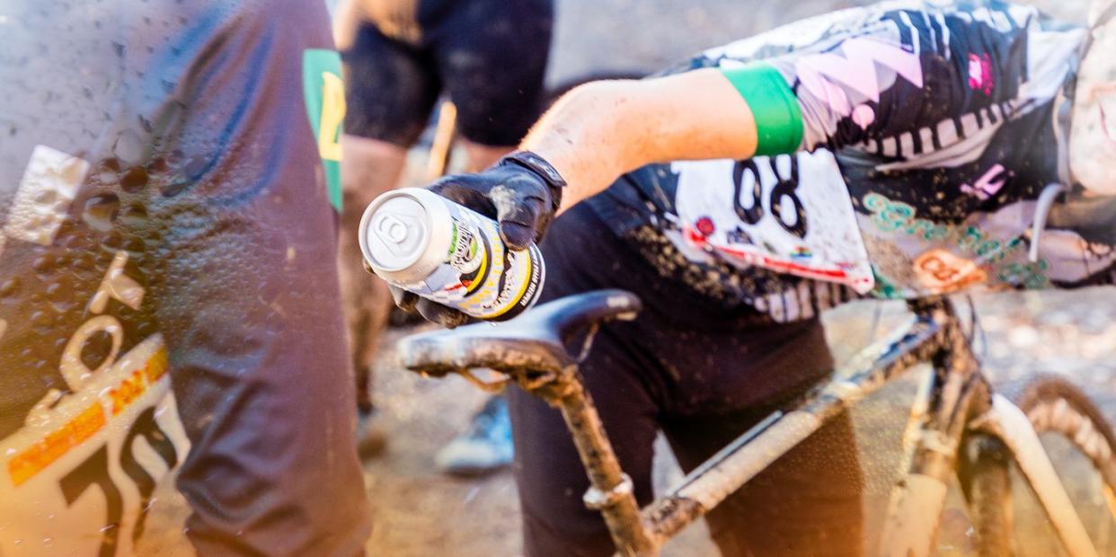 cyclist handing off beer at cyclocross event