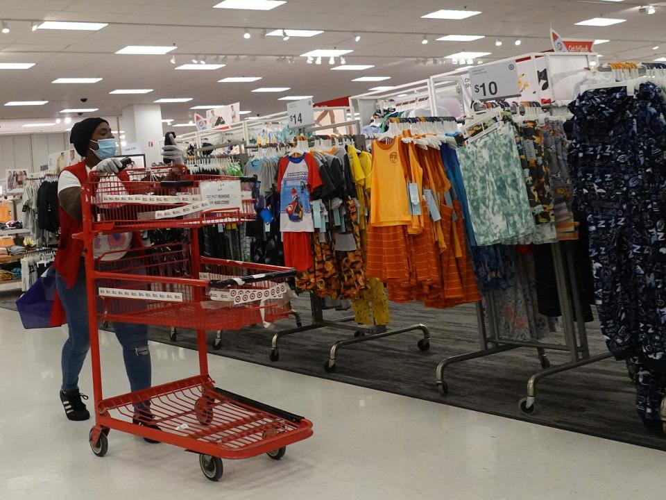 Target employee pushing cart walks in aisle of Target store