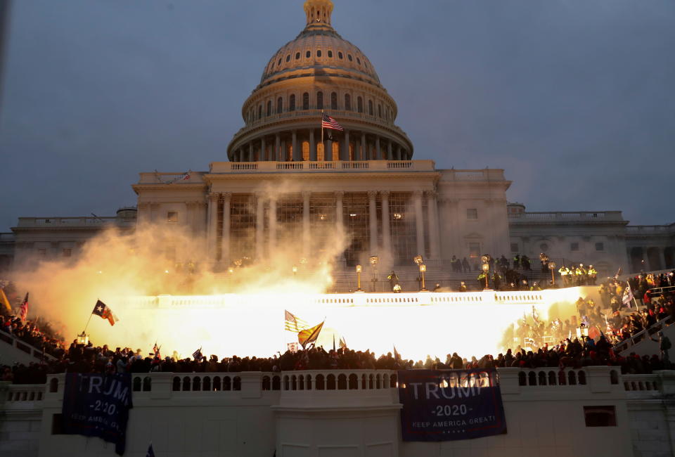 An explosion caused by a police munition is seen while supporters of then-President Donald Trump riot in front of the U.S. Capitol Building on Jan. 6, 2021. 