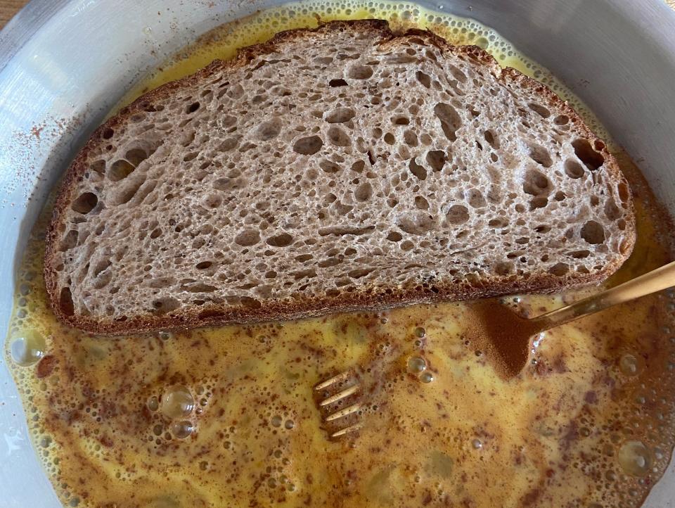 bread soaking in an egg mixture for french toast