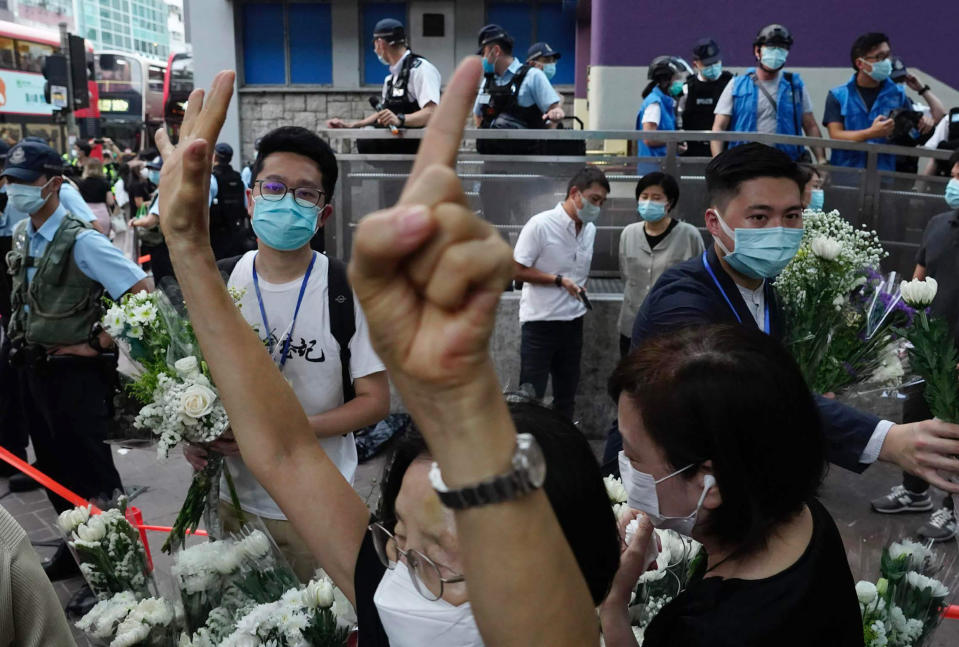 A protester gestures with five fingers, signifying the "Five demands and not one less" outside the Prince Edward subway station in Hong Kong Monday, Aug. 31, 2020. Aug. 31 is the first anniversary of police raid on Prince Edward subway station which resulted in widespread images of police beating people and drenching them with pepper spray in subway carriages. (AP Photo/Vincent Yu)