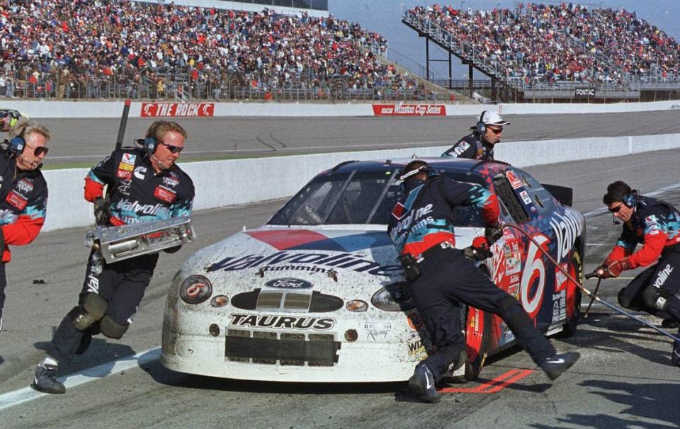 Crew members work on the car of driver Mark Martin during his last pit stop in the Dura-Lube/Big Kmart 400 at the North Carolina Motor Speedway near Rockingham, N.C., Sunday, Feb. 21, 1999. Martin gained the lead in the race after the stop and later won the race.