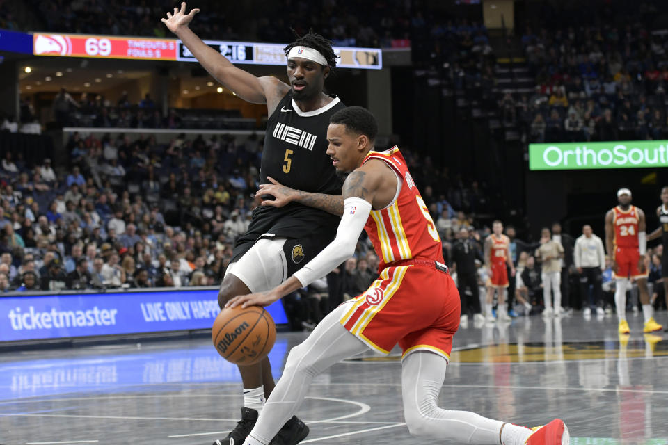 Atlanta Hawks guard Dejounte Murray, right, is defended by Memphis Grizzlies guard Vince Williams Jr. during the second half of an NBA basketball game Friday, March 8, 2024, in Memphis, Tenn. (AP Photo/Brandon Dill)