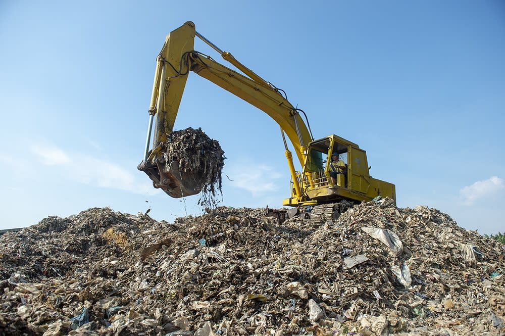 An excavator is seen clearing piles of plastic at an illegal recycling site in Jenjarom, Banting March 26, 2019. — Picture by Mukhriz Hazim