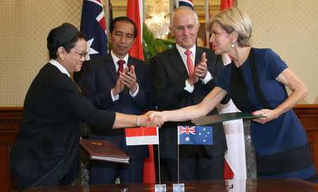 Indonesian Minister for Foreign Affairs Retno Marsudi (L) shakes hands after exchanging documents with Australian Foreign Minister Julie Bishop during a signing ceremony as Indonesian President Joko Widodo (2nd L) and Australian Prime Minister Malcolm Turnbull watch on at Admiralty House in Sydney, Australia, February 26, 2017. REUTERS/David Moir/Pool