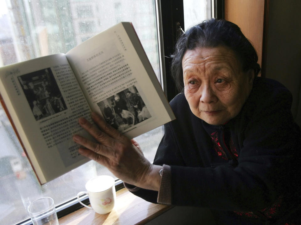 FILE - AIDS activist Gao Yaojie displays a book she wrote about AIDS in China, during an interview in Beijing on Feb. 22, 2007. Gao, a Chinese doctor who embarrassed the government by exposing the AIDS epidemic in rural China in the 1990s and spent her last decade in exile in the United States, died Sunday, Dec. 10, 2023, at her home in Manhattan. She was 95. (AP Photo/Greg Baker, File)