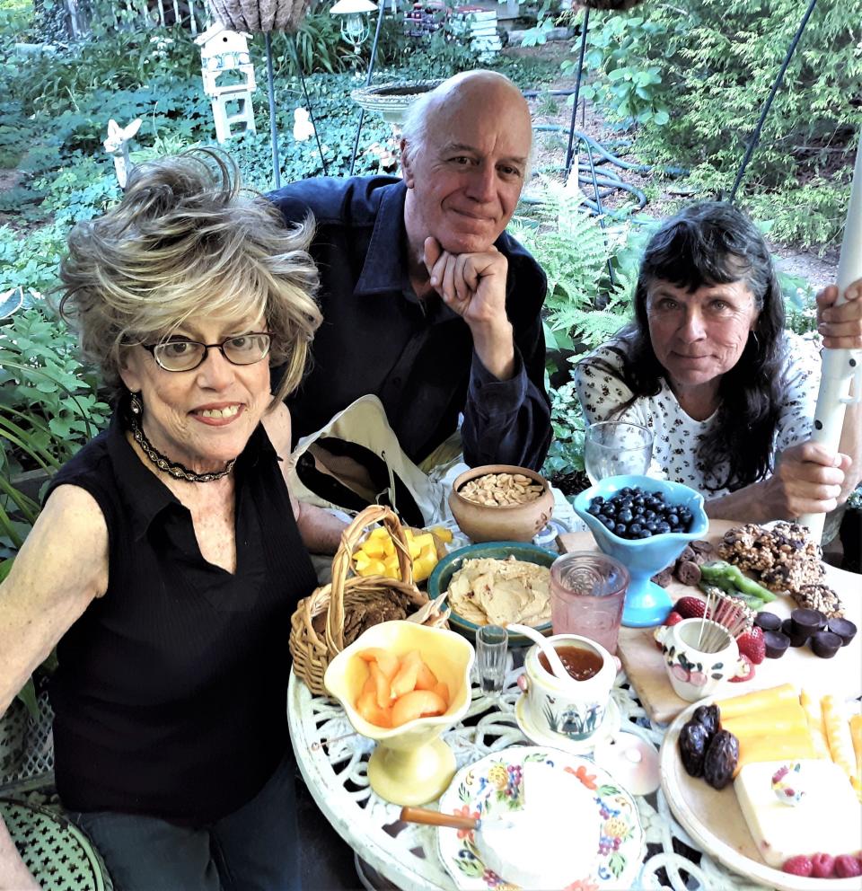 Saralee Perel, left, Larry Brown and Bettina Brown share lunch in her backyard. [Bob Daly]