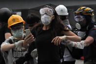 In this photo taken on Wednesday, June 12, 2019, protesters flee after police fired tear gas during a massive demonstration outside the Legislative Council in Hong Kong. Young Hong Kong residents protesting a proposed extradition law that would allow suspects to be sent to China for trial are seeking to safeguard their identities from potential retaliation by authorities employing mass data collection and sophisticated facial recognition technology. (AP Photo/Kin Cheung)