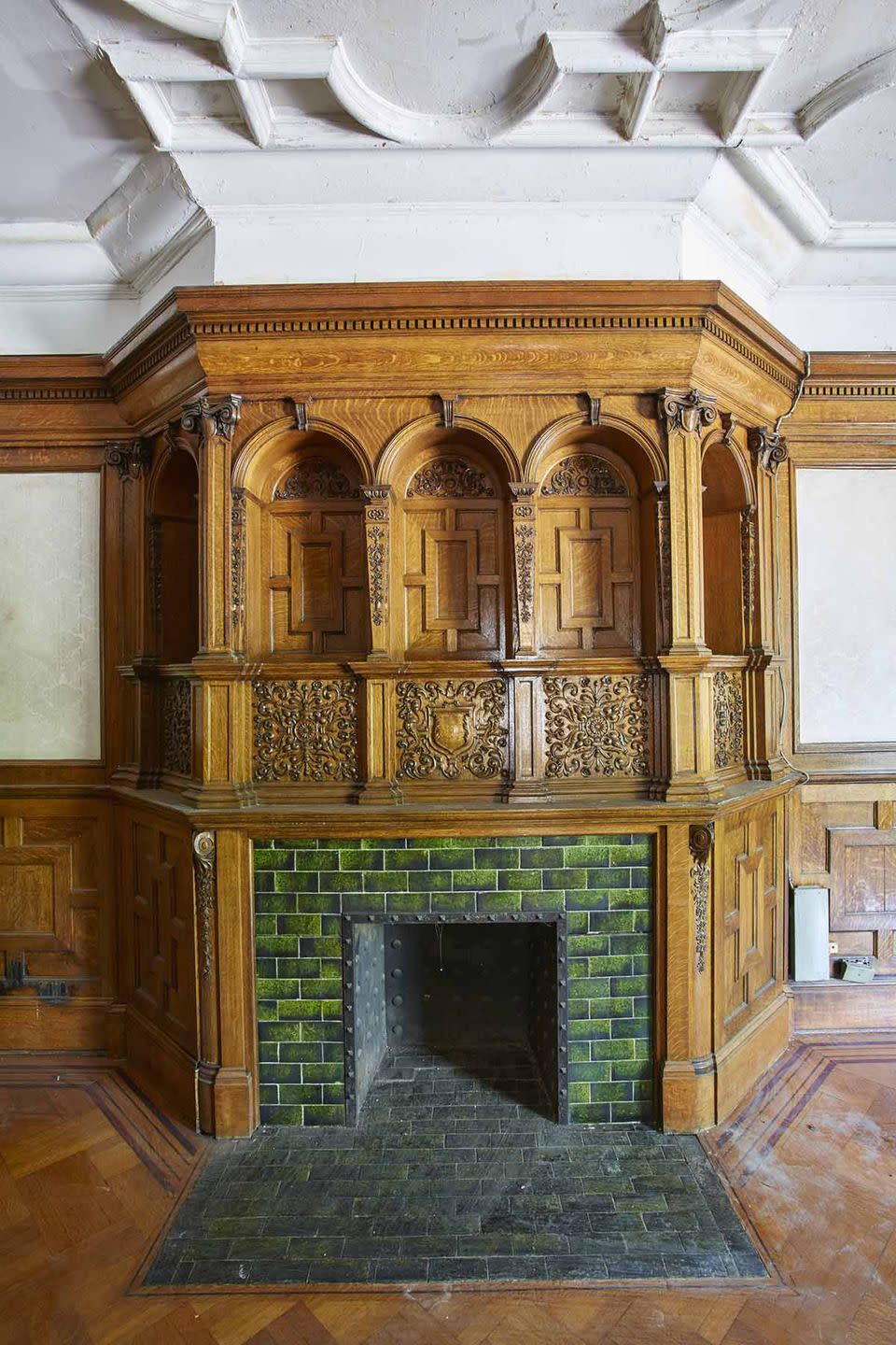 It has several original mantels, including this one with intricate wood details.