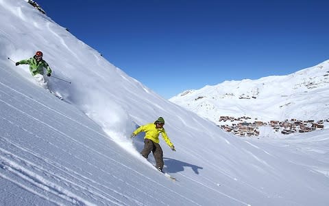 A skier and a snowboarder on the slope in Val Thorens