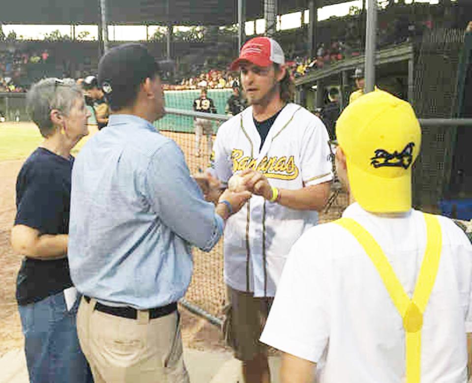 Josh Reddick, in Bananas jersey, signs an autograph for fans during a 2016 Savannah Bananas game at Grayson Stadium.