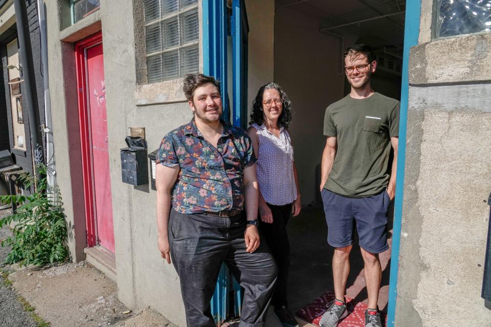 Louis Langer,  Sarah Summers and Dillon Fagan at the entrance to their cooperative in Olneyville.