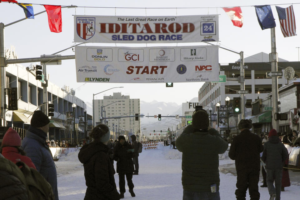 The fan-friendly ceremonial start of Iditarod Trail Sled Dog Race was held in downtown Anchorage, Alaska, on Saturday, March 2, 2024. The Chugach Mountains are seen in the background behind the banner strung over Fourth Avenue. (AP Photo/Mark Thiessen)
