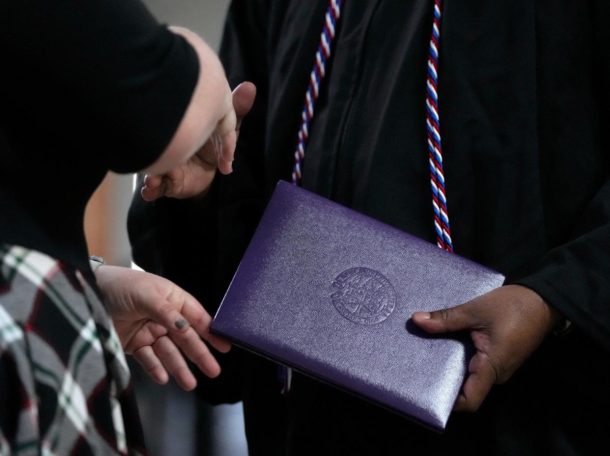 man receives his dipolma from Ashland University during a college graduation ceremony at Grafton Correctional Institution in Lorain County.