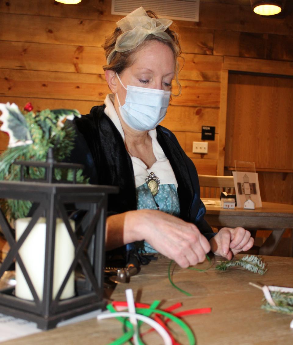 Monroe resident Vicky Pontious makes Christmas decorations using sprigs from pine branches. Early French settlers did not decorate their homes with Christmas trees. Instead, they gathered pieces of greenery, tied them with ribbon and hung them in windows.