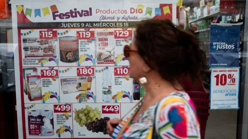 Mujer pasando por un supermercado.