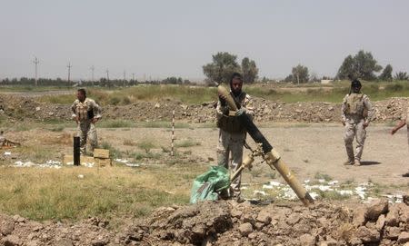 Members of the Iraqi security forces prepare to fire mortar bombs during clashes with Sunni militant group Islamic State of Iraq and the Levant (ISIL) in Muqdadiyah in Diyala province June 19, 2014. REUTERS/Stringer