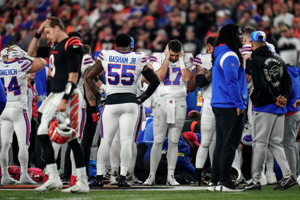 The Buffalo Bills gather while CPR is administered to Buffalo Bills safety Damar Hamlin (3) after a play in the first quarter against the Cincinnati Bengals.