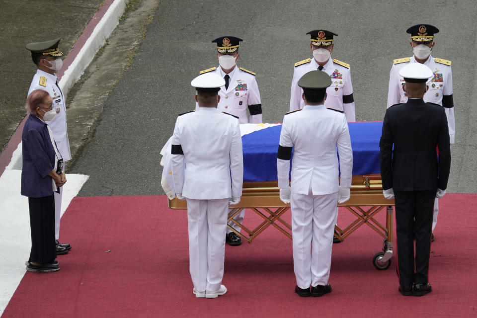 Widow and former first lady Amelita Ramos, left, with military chief Lieutenant General Bartolome Vicente Bacarro, second from left, stands beside the flag-draped casket of her husband, the late former Philippine President Fidel V. Ramos, during his state funeral at the Heroes' Cemetery in Taguig, Philippines on Tuesday Aug. 9, 2022. Ramos was laid to rest in a state funeral Tuesday, hailed as an ex-general, who backed then helped oust a dictatorship and became a defender of democracy and can-do reformist in his poverty-wracked Asian country. Ramos died at age 94. (AP Photo/Aaron Favila)