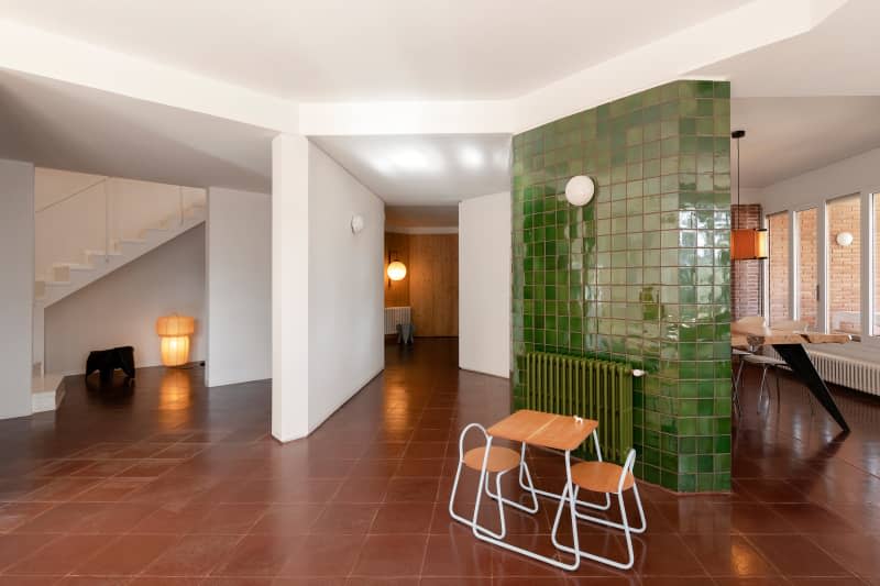 Small table in front of green tiled wall.